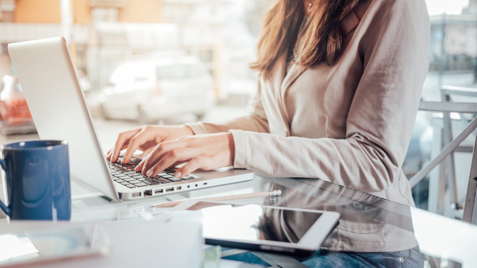 Young adult holding credit card and smartphone doing online banking transaction