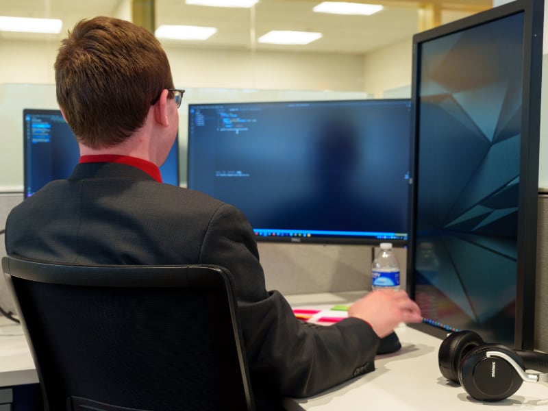 employee working on multiple monitors