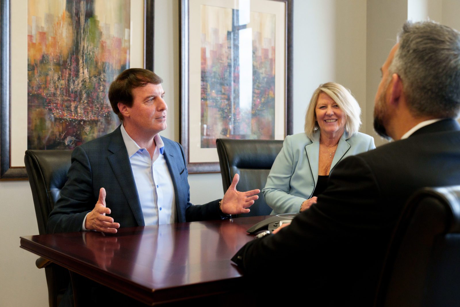 Group Discussion Around Table man working at desk offering security services